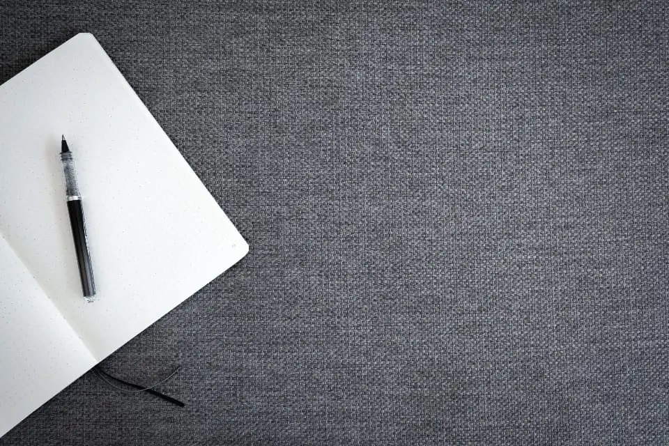 Notizbuch und Stift auf grauem Tisch