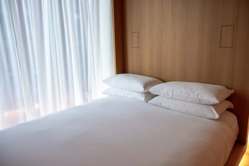 Frisch bezogenes Hotelbett mit weißer Bettwäsche